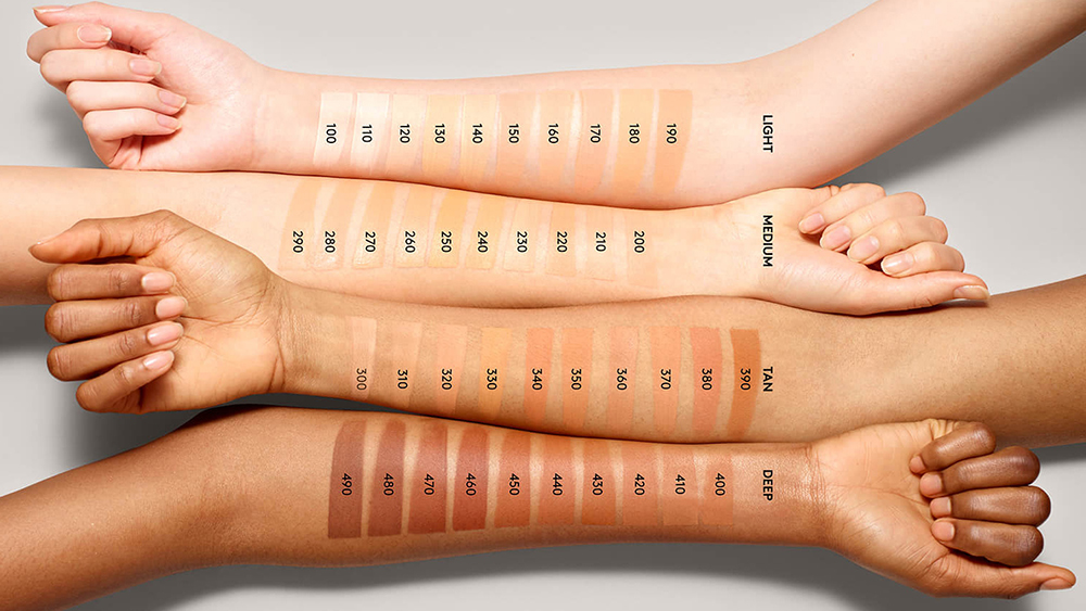 The entire Fenty Beauty line of foundations is shown on four arms, each a different skin tone.