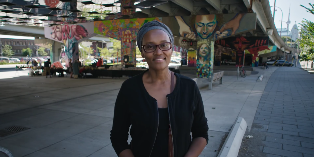 A woman stands in front of Underpass Park in the West Don Lands of downtown Toronto.