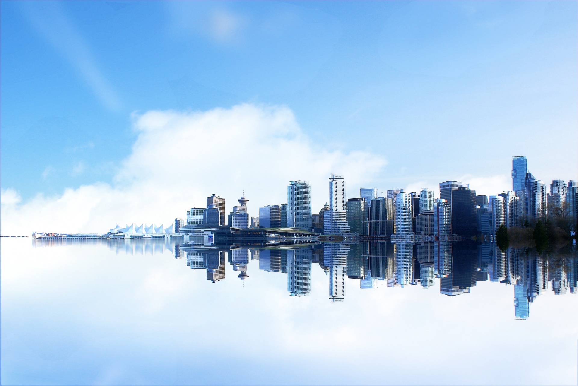 The Vancouver skyline is reflected in the harbour.