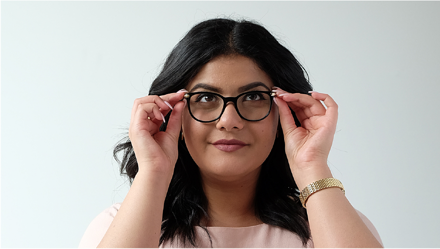 A woman puts glasses on.