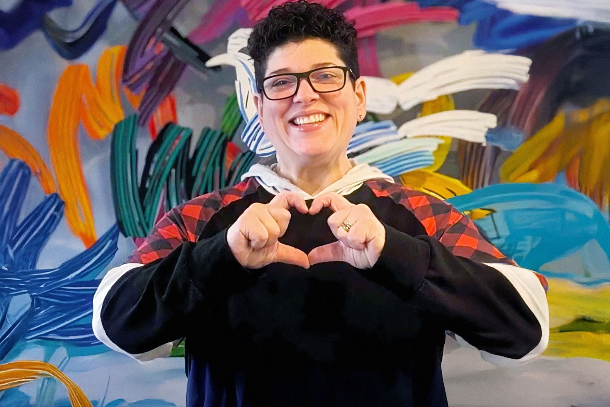 Works Design CFO and principal Ellie Rosen makes a heart hands gesture for the camera.