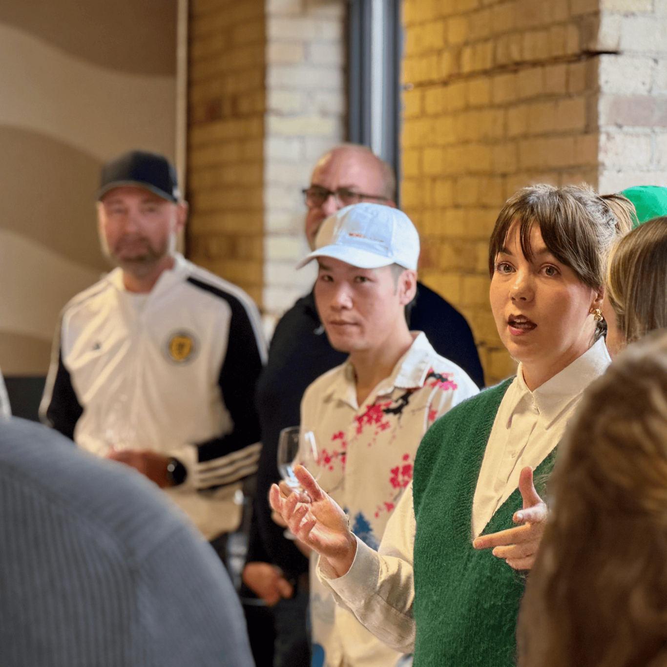Works Design colleagues listen to a talk at a wine tasting event in the company’s office.